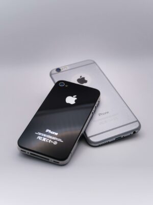 Two sleek smartphones on a gray surface showcasing minimalist design and technology.